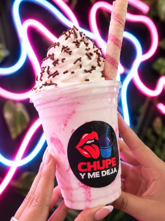 Malteada rosada con crema, chispas de chocolate y barquillo